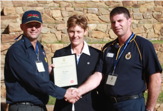 Photo of The Dog Line's BossMan presenting the 2003 Ranger of the Year Award to the winner. Celebrates dedication and excellence in animal care and training, reflecting The Dog Line's commitment to supporting the dog community